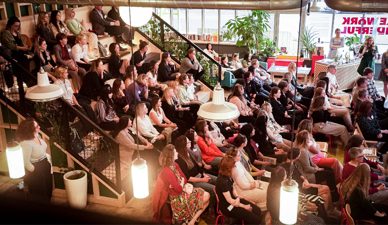 Audience looking towards stage with bright lights at the forefront
