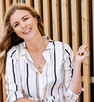 Person holding a pencil smiling at the camera.