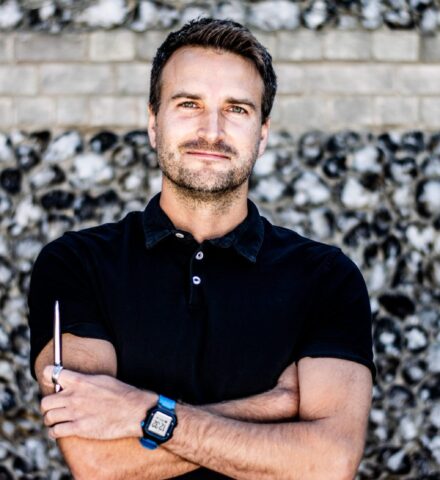 Person holding a pencil looking at the camera.