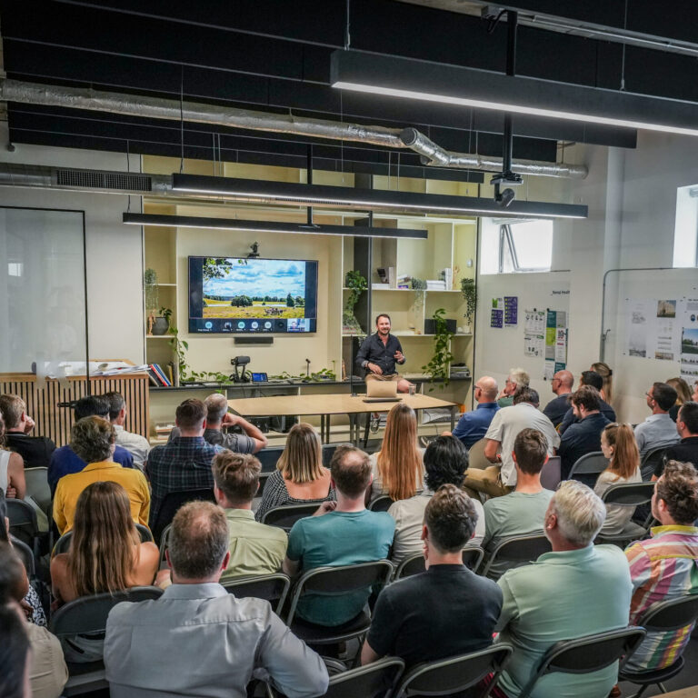A person presenting to a large group of people sat down facing the presenter.