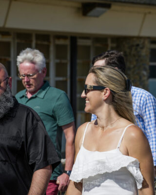 Four people walking, smiling at the camera.