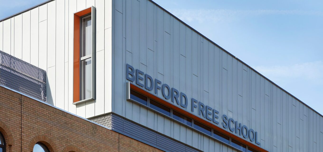 Metal-cladded roof box extension on Bedford Free School main brick building.
