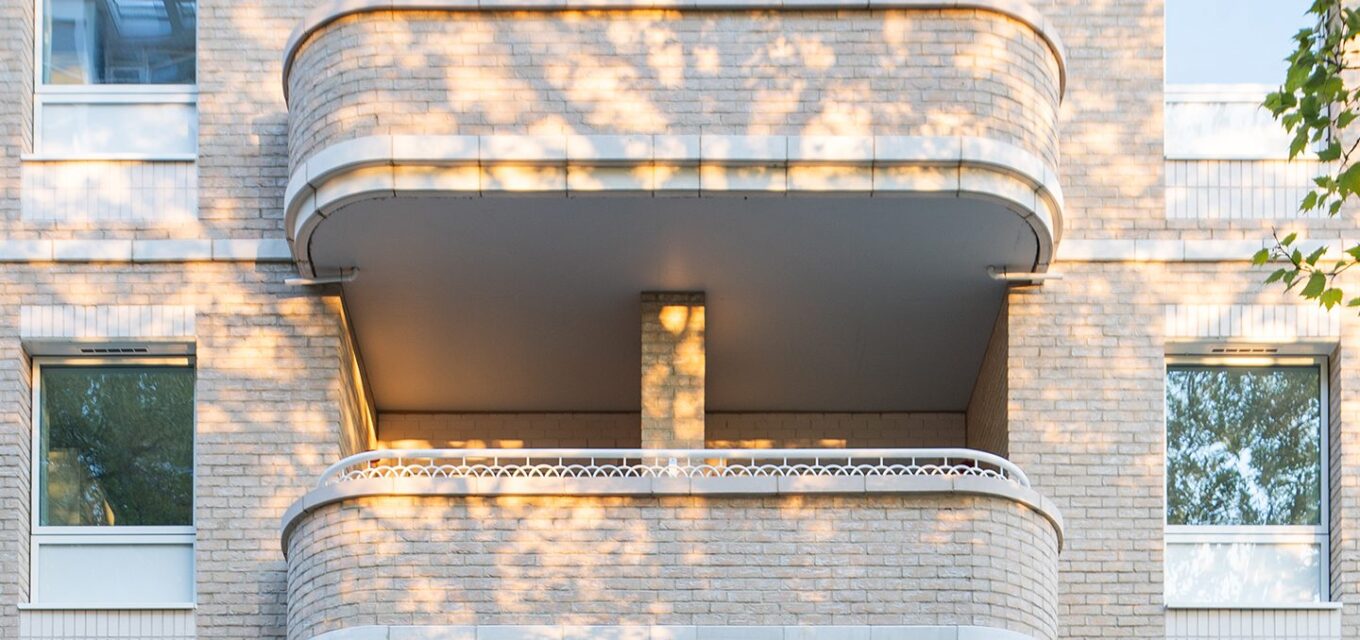 Two Art Deco style curved balconies with white brick details.