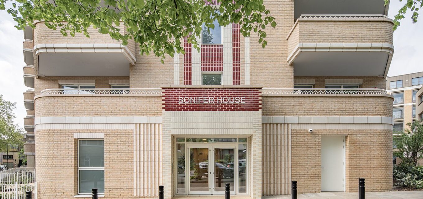 Entrance of an Art Deco style residential building with glazed brick and tile details above the door.