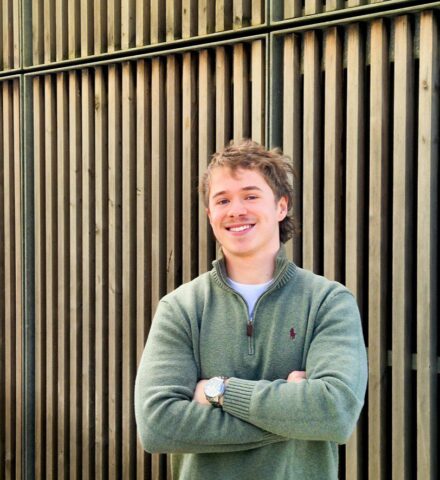 Person with arms crossed, smiling and looking at the camera