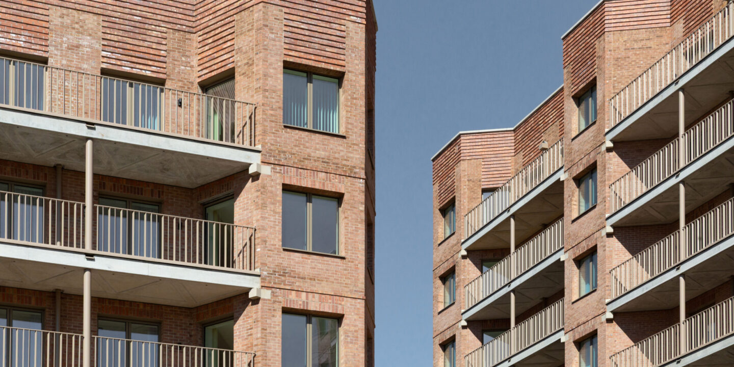 Two high rise residential buildings opposite each other, with a slither of blue sky appearing between them