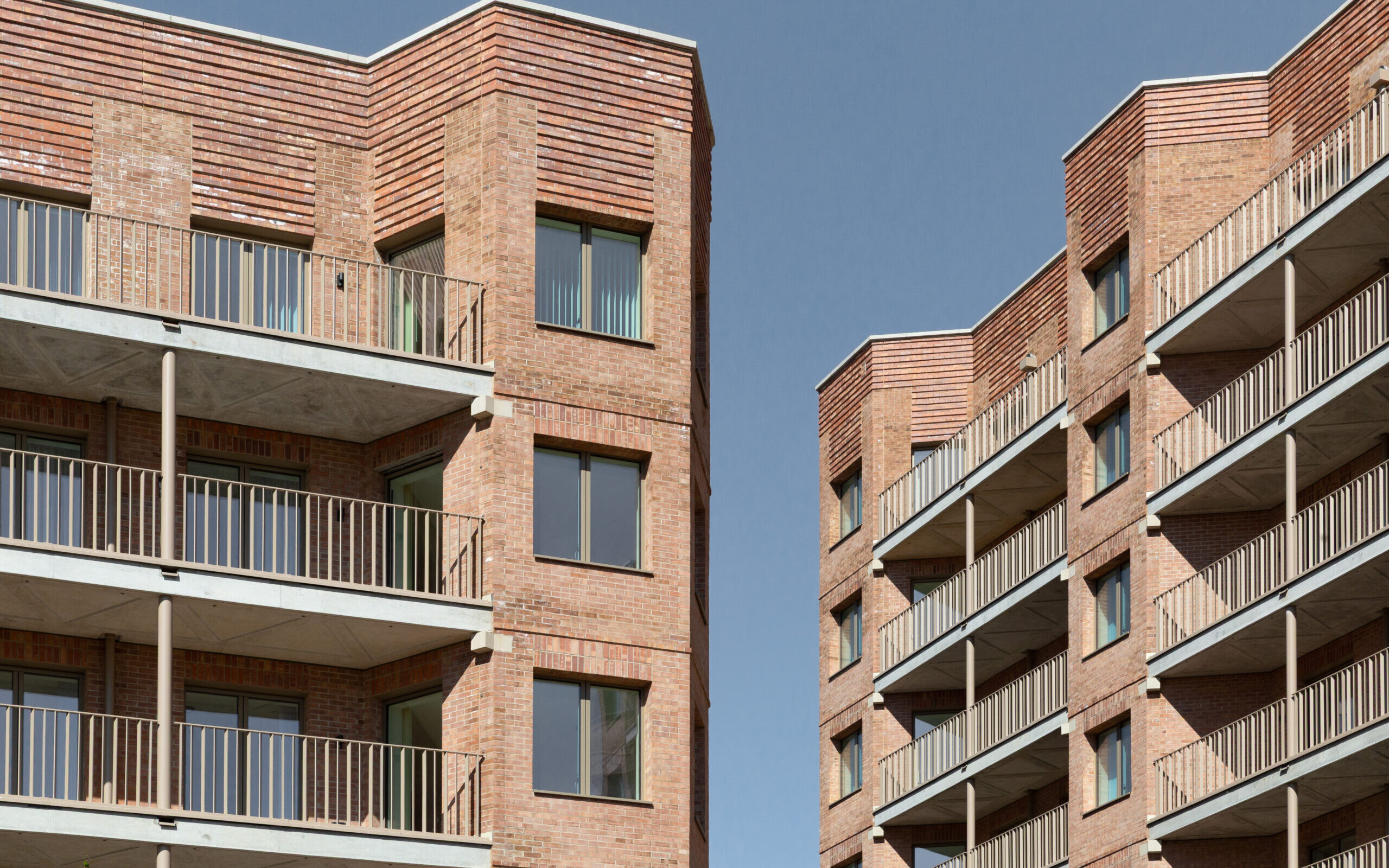 ECE Architecture Ltd — Two high rise residential buildings opposite each other, with a slither of blue sky appearing between them