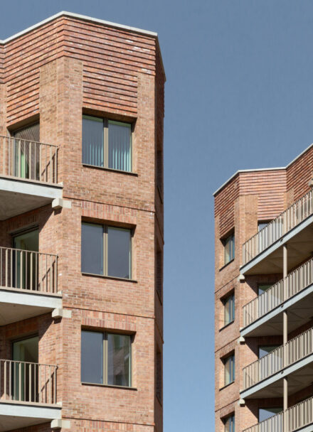 Two high rise residential buildings opposite each other, with a slither of blue sky appearing between them